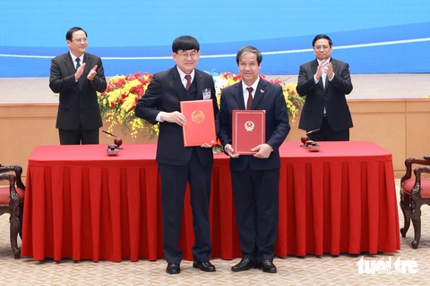 Thúc đẩy làm đường cao tốc, đường sắt nối Việt Nam và Lào- Ảnh 5. Hai bộ trưởng giáo dục Việt Nam và Lào trao đổi văn kiện - Ảnh: NGUYỄN KHÁNH
