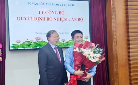 Quy định mới: Hiệu trưởng có thể được bổ nhiệm lại không hạn chế số lần- Ảnh 1. Thứ trưởng Bộ Văn hóa, Thể thao và Du lịch Tạ Quang Đông trao quyết định công nhận hiệu trưởng Trường đại học Văn hóa TP.HCM và tặng hoa chúc mừng ông Lâm Nhân tháng 12-2023 - Ảnh: L.N.