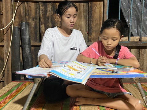 Cô sinh viên ngành y vượt khó nuôi ước mơ thoát nghèo- Ảnh 2. Mỗi khi về quê là chị hai Anh Thư luôn kèm đứa em út học bài - Ảnh: LAN NGỌC
