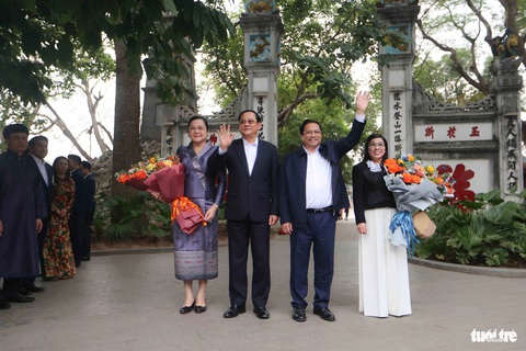 Thủ tướng Việt Nam và Lào cùng dạo hồ Gươm, uống cà phê với sinh viên- Ảnh 3. Hai Thủ tướng và phu nhân vẫy tay chào người dân trước khi vào tham quan đền Ngọc Sơn - Ảnh: NGUYỄN KHÁNH