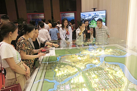 Giá bất động sản: Nơi cần không giảm, giảm mạnh nơi người dân không về ở- Ảnh 5. Khách tìm hiểu dự án bất động sản ở quận 7 (TP.HCM) - Ảnh: T.T.D.