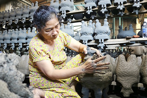 Vực dậy nghề đúc lư đồng- Ảnh 6. Bà Tư (63 tuổi), thợ lành nghề gần 40 năm tại cơ sở lư đồng Năm Toàn, đang áo vỏ khuôn bằng hỗn hợp đất sét và trấu trước khi đưa vào lò nung