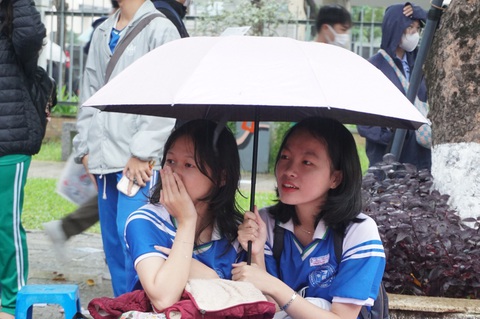 Hàng ngàn học sinh Đà Nẵng đội mưa dự Chương trình tư vấn tuyển sinh - hướng nghiệp- Ảnh 3. Đôi bạn say sưa nghe tư vấn dưới mưa - Ảnh: ĐOÀN CƯỜNG