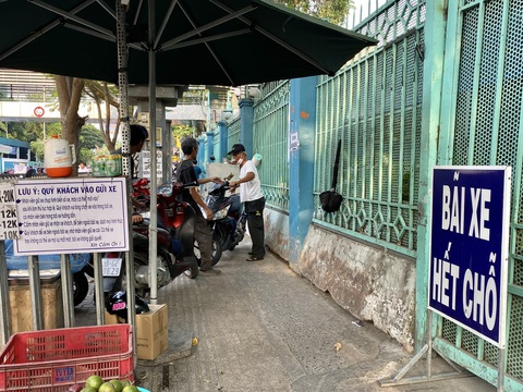 Cận cảnh những bãi giữ xe ‘chặt chém’ dịp cuối năm- Ảnh 5. Bãi xe tại Bệnh viện Bình Dân (TP.HCM) treo bảng hết chỗ, người dân phải tìm chỗ gửi xe bên ngoài - Ảnh: TIẾN QUỐC