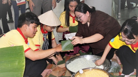 Trải nghiệm nhịp sống học sinh, sinh viên thế hệ mới- Ảnh 1. Chiến sĩ Xuân tình nguyện được hướng dẫn gói bánh chưng, bánh tét tại Ngày hội học sinh, sinh viên toàn quốc - Ảnh: C.TRIỆU