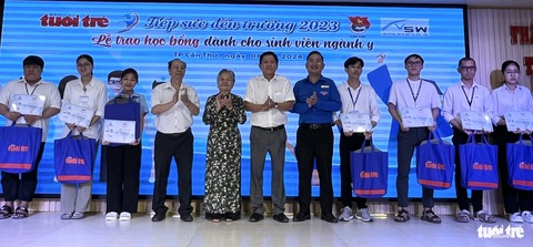 Nâng bước đến trường cho các y, bác sĩ tương lai của miền Tây- Ảnh 6. Nhà báo Hoàng Trí Dũng - trưởng văn phòng đại diện báo Tuổi Trẻ vùng Tây Nam Bộ (thứ 6 từ trái sang) và anh Lâm Văn Tân - phó bí thư Thành Đoàn Cần Thơ (thứ 7 từ trái sang) cùng đại diện nhà tài trợ trao học bổng cho các sinh viên - Ảnh: LAN NGỌC