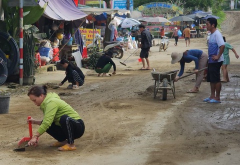 Người dân mỗi ngày đi cầu cũ sình lầy 'hóng' cầu trăm tỉ đang... chậm tiến độ- Ảnh 6. Người dân phải dọn bùn đất mỗi ngày - Ảnh: T.M