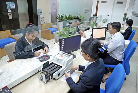 Hàng triệu USD tiền mặt từ đâu ra?- Ảnh 3. Giao dịch kiều hối tại Công ty kiều hối Đông Á (quận 3, TP.HCM) vào chiều 8-1 - Ảnh: PHƯƠNG QUYÊN