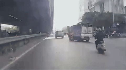Vụ chèn ngã 2 người rồi bỏ chạy: Rà soát camera truy tìm xe tải cố tình gây tai nạn- Ảnh 1. Cảnh chiếc xe tải chèn ngã hai người trên xe máy - Ảnh: D.A.