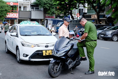 Xử lý ô tô đậu tràn lan dưới lòng đường ở trung tâm TP.HCM - Ảnh 1.