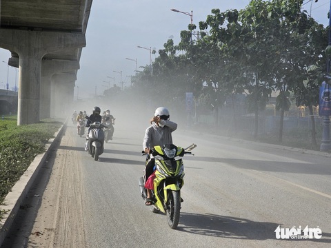 Người dân TP.HCM khổ sở băng qua con đường bụi mịt mù như sương khói - Ảnh 2.