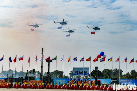 Mãn nhãn hình ảnh lễ khai mạc Triển lãm quốc phòng quốc tế Việt Nam 2024 - Ảnh 4. 4 trong số 7 chiếc trực thăng họ Mi trình diễn kéo cờ Tổ quốc, cờ Đảng, cờ triển lãm ngang qua khán đài, phía dưới là dàn trống hội - Ảnh: NAM TRẦN Quân đội Nhân dân Việt Nam: Niềm tự hào dân tộc - Ảnh 3.
