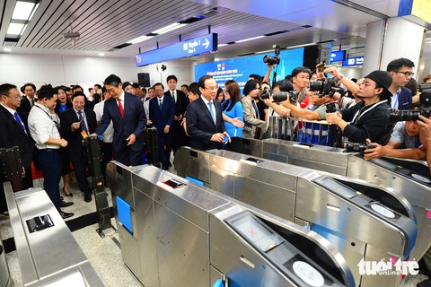 Sáng khai trương, ga Bến Thành chật cứng người dân muốn lên tàu metro số 1 - Ảnh 7. Ga Bến Thành chật cứng người dân muốn lên tàu metro số 1 - Ảnh 12.