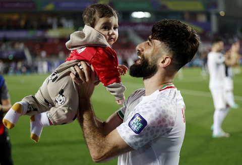 Xác định đủ 8 đội vào tứ kết Asian Cup 2023- Ảnh 1. Cầu thủ Iran ăn mừng cùng cậu con trai nhỏ - Ảnh: REUTERS