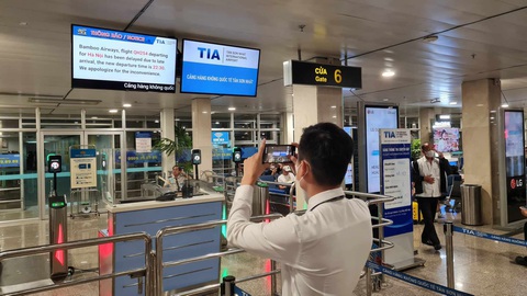 Nhiều chuyến bay delay liên tục vì thời tiết xấu phía Bắc- Ảnh 2. Nhiều chuyến bay bị delay, khách thấp thỏm chụp hình chờ xem thông tin đổi giờ khởi hành mới - Ảnh: CTV
