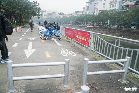 Người Hà Nội trải nghiệm tuyến đường dành cho xe đạp trong ngày đầu mở cửa- Ảnh 7. Tuy nhiên, việc rào chắn để tránh xe máy đi vào ít nhiều cũng gây khó khăn cho người đi xe đạp khi đưa xe vào - Ảnh: PHẠM TUẤN