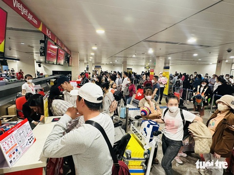 Sân bay Tân Sơn Nhất đông khách hơn nhưng vẫn ổn- Ảnh 3. Khu vực quầy Vietjet rất đông khách đứng đợi làm thủ tục check-in - Ảnh: CÔNG TRUNG