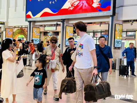 Sân bay Tân Sơn Nhất đông khách hơn nhưng vẫn ổn- Ảnh 6. Khách nước ngoài thong dong đi lại chiều 22 Tết tại sân bay Tân Sơn Nhất - Ảnh: CÔNG TRUNG