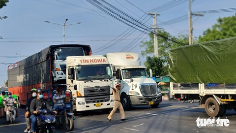 Xe tải nặng vẫn qua cầu Rạch Miễu trong giờ cấm, gây kẹt xe- Ảnh 1. Lực lượng cảnh sát giao thông Công an tỉnh Tiền Giang xử lý 2 chiếc xe tải nặng chạy qua cầu Rạch Miễu trong giờ cấm - Ảnh: MẬU TRƯỜNG