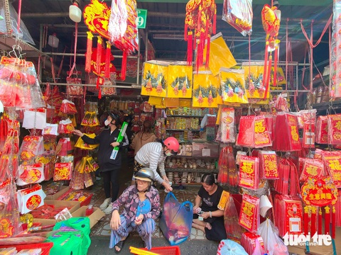 Ông Công ông Táo sắp về trời mà chủ tiệm vẫn mãi ngóng khách mua- Ảnh 1. Khách mua sắm đồ cúng ông Công ông Táo tại chợ Thiếc (quận 10, TP.HCM) chiều ngày 1-2 - Ảnh: NHẬT XUÂN