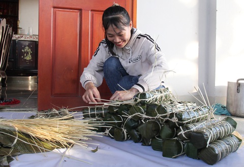 Gói bánh tét tặng bà con nơi không điện, không sóng di động đón Tết- Ảnh 1. Chị Lê Thị Thùy Dung từ TP Quảng Ngãi lên xã Nghĩa Trung, huyện Tư Nghĩa gói bánh tét tặng bà con thôn Nước Đang - Ảnh: TRẦN MAI