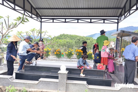 Người dân xứ Quảng viếng tổ tiên ngày đầu năm mới- Ảnh 1. Một gia đình thắp nhang mộ người thân sáng mùng 1 Tết - Ảnh: LÊ TRUNG