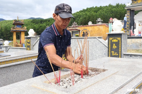 Người dân xứ Quảng viếng tổ tiên ngày đầu năm mới- Ảnh 5. Người dân thắp nhang ở mộ - Ảnh: LÊ TRUNG