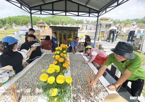 Người dân xứ Quảng viếng tổ tiên ngày đầu năm mới- Ảnh 6. Người lớn, trẻ nhỏ cùng thắp nhang ở mộ tổ tiên - Ảnh: LÊ TRUNG