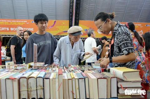 Cụ ông Nguyễn Văn Báu cùng cháu nội mâm mê từng cuốn sách - Ảnh: TỰ TRUNG Cụ ông Nguyễn Văn Báu cùng cháu nội Nghĩa Huy (bên trái) mân mê từng cuốn sách - Ảnh: TỰ TRUNG