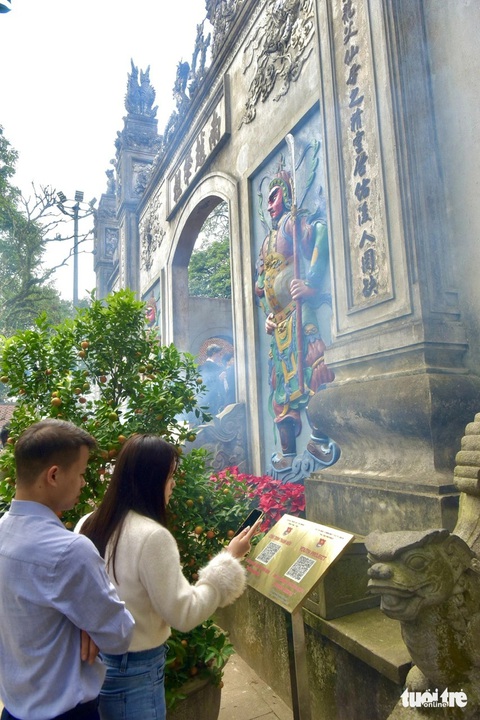 Vợ chồng chị Hảo (Thị xã Phú Thọ, Phú Thọ) quét mã để tìm hiểu thêm về thông tin di tích tại Đền Thượng - Ảnh: T.T.D. Vợ chồng chị Hảo (thị xã Phú Thọ, tỉnh Phú Thọ) quét mã để tìm hiểu thêm về thông tin di tích tại đền Thượng - Ảnh: T.T.D.