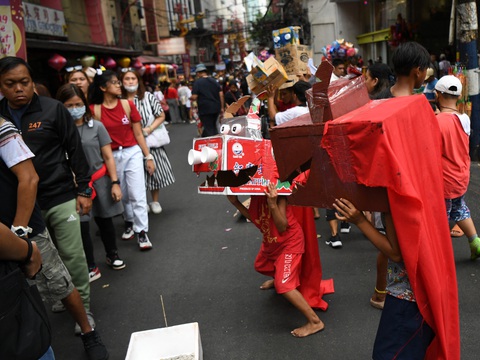 Trẻ em vui đùa cùng những chú lân giả tự chế từ bìa cacton trên đường phố Manila sáng mùng 1 Tết - Ảnh: AFP Trẻ em vui đùa cùng những chú lân giả tự chế từ bìa các tông trên đường phố Manila sáng đầu năm - Ảnh: AFP