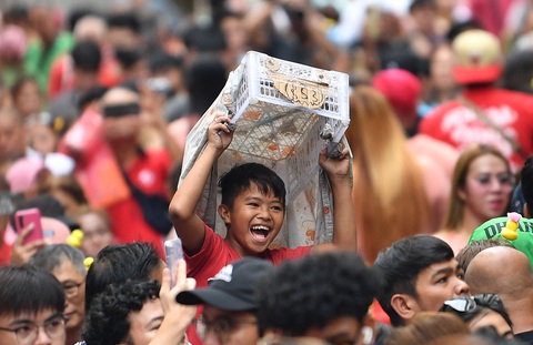 Bé trai ở Manila (Philippines) vui đùa bên chú lân giả là từng khay nhựa - Ảnh: AFP Bé trai ở Manila vui đùa bên chú lân giả làm từ khay nhựa - Ảnh: AFP
