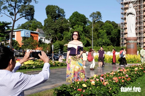 Đi cà phê bệt gần nhà thờ Đức Bà, dạo Đường sách ngày mùng 2 Tết- Ảnh 4. Người dân tập trung trước khu vực nhà thờ Đức Bà (quận 1) - một trong những biểu tượng của TP.HCM để cầu nguyện, chụp ảnh dịp đầu năm