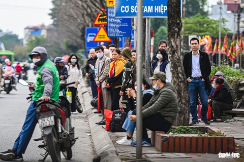 Người Hà Nội ùn ùn rời thành phố đi du xuân, cửa ngõ ùn tắc hàng km- Ảnh 9. Các điểm đón xe trên quốc lộ 1 đông người đứng chờ đợi