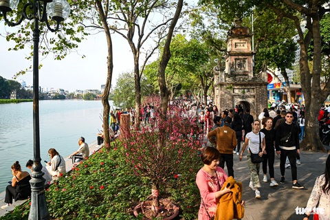 Quanh hồ Gươm kín đặc người chiều mùng 2 Tết, khách nước ngoài xếp hàng thăm phố cổ- Ảnh 4. Không gian quanh hồ Gươm được trang trí bởi nhiều sắc hoa. Chiều nay trời nắng ấm khiến không khí du xuân thêm tấp nập - Ảnh: HỒNG QUANG