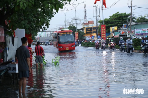 Tiền Giang: Nhiều tuyến đường, nhà cửa bị ngập do triều cường- Ảnh 1. Triều cường dâng cao đã khiến xe cộ đi lại gặp nhiều khó khăn - Ảnh: HOÀI THƯƠNG