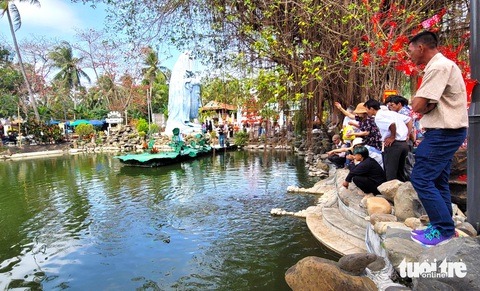 Nhiều người dân, phật tử cho cá ăn vào đầu năm mới - Ảnh: NGUYỄN HOÀNG Nhiều người dân, phật tử cho cá ăn vào đầu năm mới ở chùa Thanh Lương - Ảnh: NGUYỄN HOÀNG