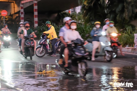 Triều cường đạt đỉnh, người dân TP.HCM bì bõm dắt xe ngày mùng 3 Tết- Ảnh 9. Dưới chân cầu Tân Thuận 2 (quận 7) hướng rẽ vào Trần Xuân Soạn, nhiều người thấy cảnh nước ngập liền quay đầu xe để đi đường khác
