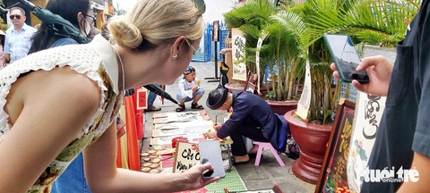 Hội An tấp nập khách, bánh mì Phượng nhiều người xếp hàng chờ mua- Ảnh 3. Du khách nước ngoài thích thú lưu lại hình ảnh ở Hội An - Ảnh: ĐOÀN CƯỜNG
