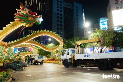 Linh vật rồng lưu lại đường hoa Nguyễn Huệ hết tháng giêng- Ảnh 1. Những cây kiểng lớn được công nhân chở về nơi tập kết để chăm sóc, bảo dưỡng, trong khi linh vật rồng sẽ được lưu lại đến hết tháng giêng