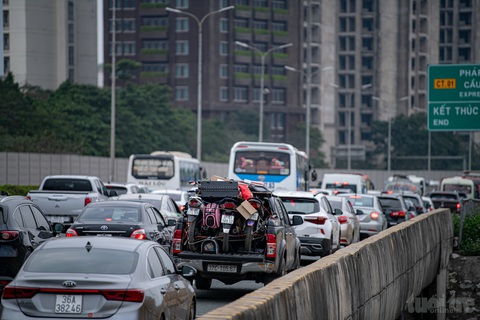 Chiều mùng 5 Tết, cửa ngõ thủ đô ùn tắc kéo dài, vành đai 3 thông thoáng- Ảnh 2. Một chiếc xe bán tải chở 3 chiếc xe máy và nhiều đồ đạc "tiến về thủ đô" trong cảnh ùn tắc kéo dài trên cao tốc Pháp Vân - Cầu Giẽ - Ảnh: NAM TRẦN