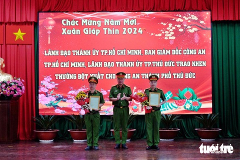 Thưởng nóng lực lượng phá án vụ cô gái mất tích 6 ngày- Ảnh 2. Thượng tá Nguyễn Đình Dương, phó giám đốc Công an TP, trao hoa và thư khen cho các chiến sĩ - Ảnh: PHƯƠNG NHI