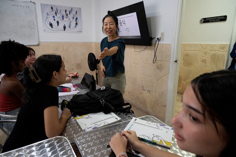 Vì sao Hàn Quốc thiết lập quan hệ với Cuba?- Ảnh 1. Giám đốc Trung tâm văn hóa và trường ngôn ngữ Hàn Quốc (Korean Cultural Center and Language School) Hohyun Joung dạy cho các học viên Cuba ở Havana ngày 30-10-2023. Tại Cuba, nhiều người trẻ yêu thích K-pop (nhạc pop Hàn Quốc) - Ảnh: AFP