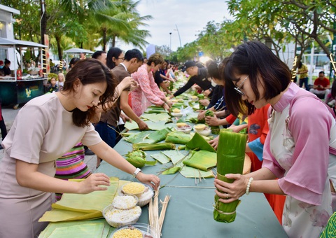 Nha Trang đón 3 chuyến tàu biển dịp Tết Nguyên đán 2024- Ảnh 5. Du khách thích thú tham gia hoạt động gói bánh Tét dịp Tết - Ảnh: MINH CHIẾN