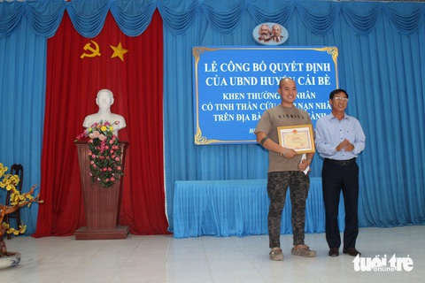 Khen thưởng người cứu bé trai bị kẻ ngáo đá ném xuống sông- Ảnh 1. Phó chủ tịch UBND huyện Cái Bè Phan Thanh Sơn trao giấy khen cho anh Phan Quốc Huy - Ảnh: H.T.