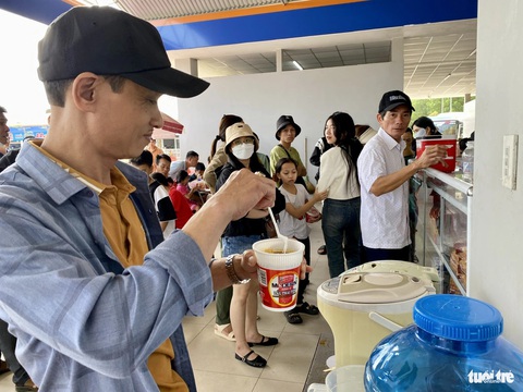Xe 'rồng rắn' nối đuôi đi chầm chậm trên cao tốc miền Trung- Ảnh 5. Trạm dừng nghỉ ở lối ra La Sơn trên cao tốc Cam Lộ - La Sơn - Hòa Liên (nối Quảng Trị vào Đà Nẵng) đông đúc người chờ mua đồ ăn - Ảnh: TRƯỜNG TRUNG