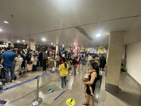Cả ngàn chuyến bay ở Tân Sơn Nhất vào mùng 8, đã có hiện tượng delay- Ảnh 2. Khu vực băng chuyền hành lý đông nghẹt khách chờ nhận vali, thùng đồ sau khi hạ cánh chuyến bay đến Tân Sơn Nhất - Ảnh: C.LINH