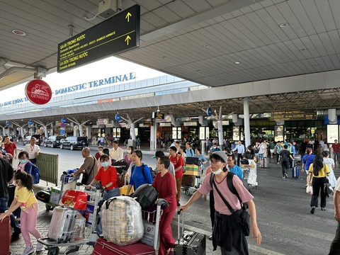 Cả ngàn chuyến bay ở Tân Sơn Nhất vào mùng 8, đã có hiện tượng delay- Ảnh 3. Khách ồ ạt quay lại sau Tết. Nhiều người kéo hành lý băng qua làn xe hướng đến khu vực nhà để xe, đón taxi, xe công nghệ... - Ảnh: C.LINH