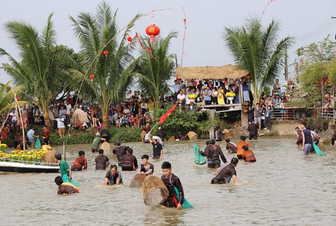 Hào hứng thi nơm cá đầu xuân- Ảnh 2. Các nơm thủ quần thảo thể hiện tài sát cá trong sự reo hò cổ vũ của ngàn người dân - Ảnh: TR.M.