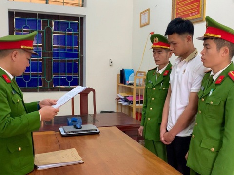 Khởi tố thanh niên đâm xe máy vào thiếu tá cảnh sát giao thông- Ảnh 1. Nguyễn Tuấn Thành (áo trắng) tại cơ quan công an - Ảnh: CACC